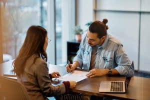 una persona firma un contratto