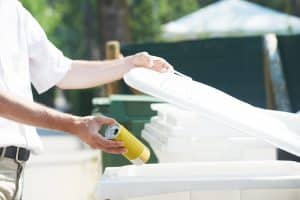 una persona getta una lattina nel secchio dell