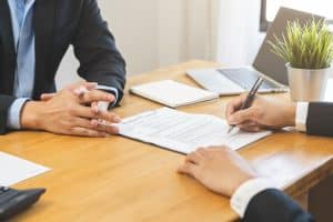una persona firma un contratto