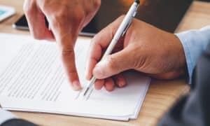 una persona firma un documento