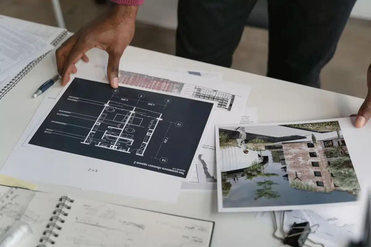 Piani di costruzione e progetti abitativi su una scrivania in ufficio con vista urbana