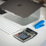 Documenti tecnici e calcolatrice su scrivania per pianificare ristrutturazioni e detrazioni fiscali