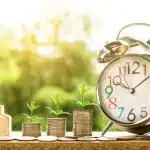 Mani che firmano documenti di mutuo su una scrivania con chiavi di casa e tazza di caffè