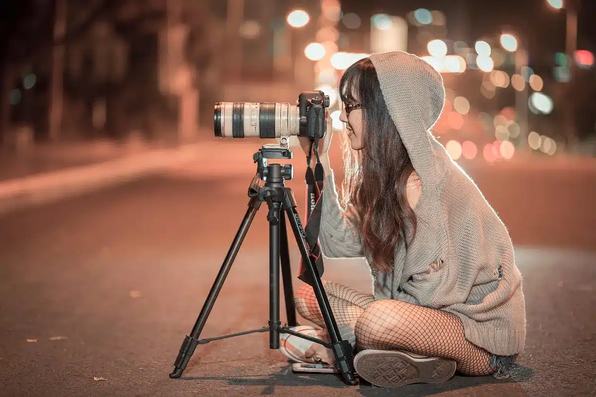 Fotografo con cavalletto che inquadra la luna piena