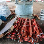 Cantiere anonimo con impalcature e materiali, operai in ombra