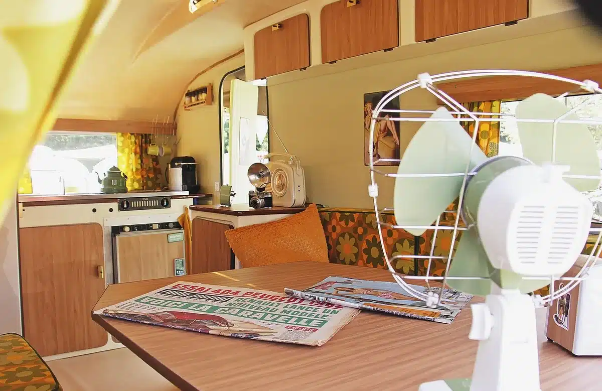 Interno di un camper con cucina compatta e scaffali organizzati